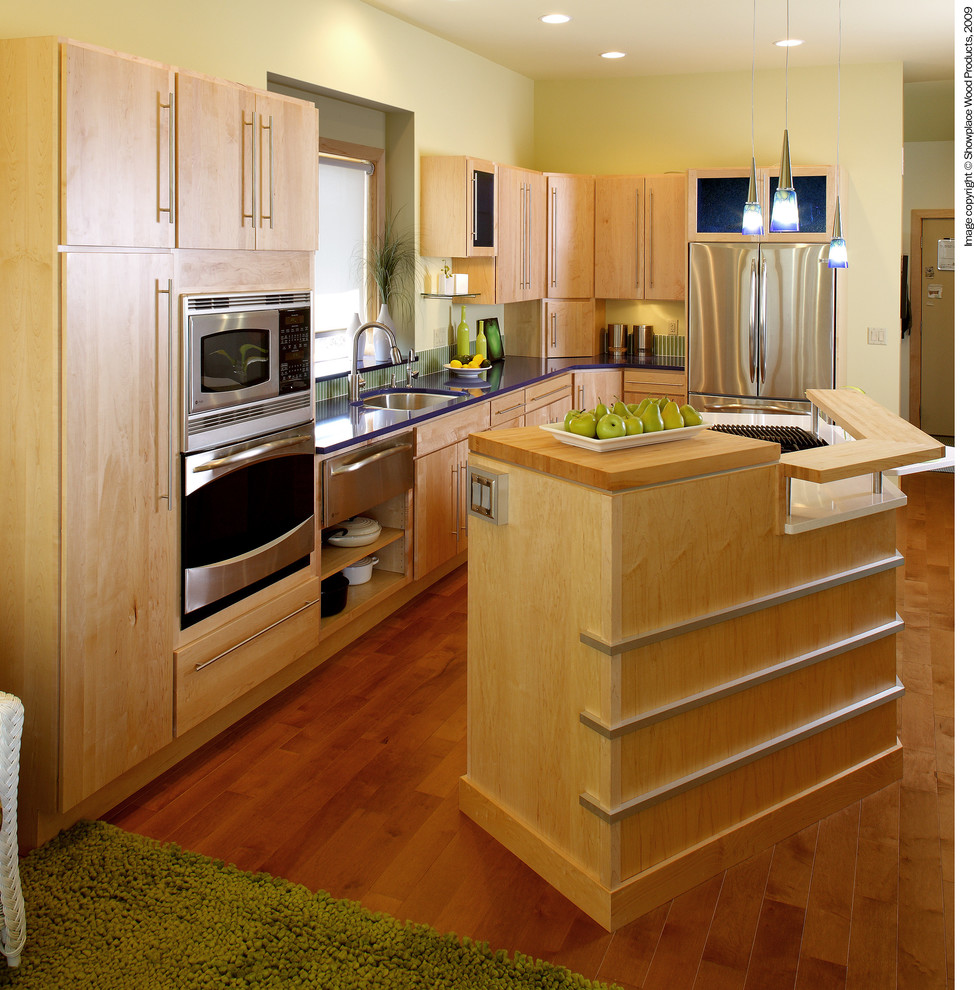 Idéer för att renovera ett avskilt, stort funkis l-kök, med en undermonterad diskho, släta luckor, skåp i ljust trä, grönt stänkskydd, stänkskydd i mosaik, rostfria vitvaror, mellanmörkt trägolv och en köksö