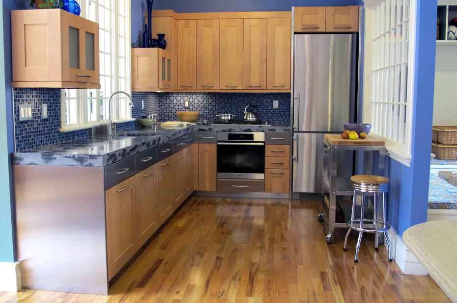 Inspiration for a mid-sized eclectic l-shaped light wood floor enclosed kitchen remodel in Boston with an undermount sink, shaker cabinets, light wood cabinets, blue backsplash, glass tile backsplash, stainless steel appliances and blue countertops