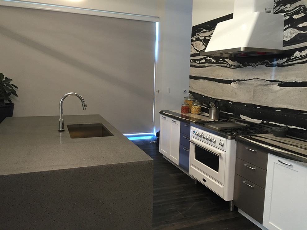Modern inredning av ett mellanstort linjärt kök och matrum, med luckor med infälld panel, vita skåp, en köksö, en undermonterad diskho, bänkskiva i koppar, svart stänkskydd, stänkskydd i sten, rostfria vitvaror och vinylgolv