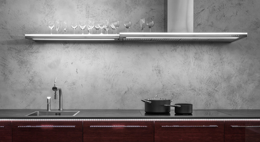 Esempio di una cucina minimal di medie dimensioni con lavello da incasso, ante lisce, ante rosse, top in granito, paraspruzzi grigio, elettrodomestici neri e pavimento in compensato