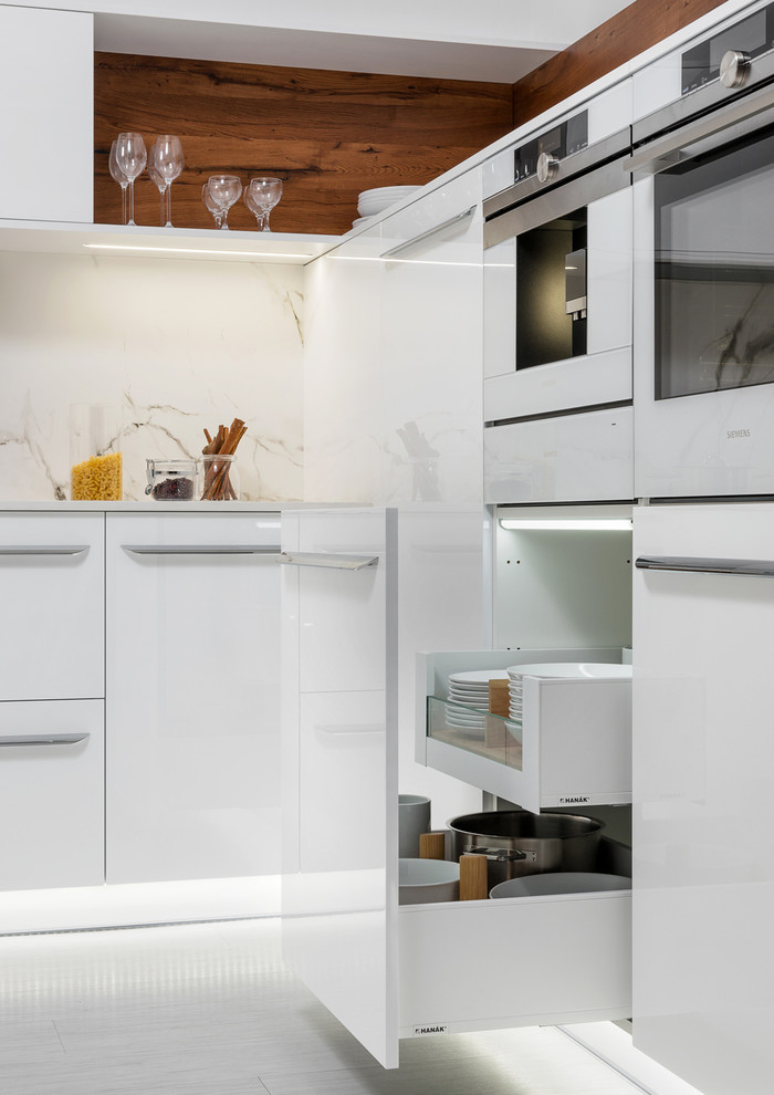 Foto di una cucina minimalista di medie dimensioni con lavello integrato, ante lisce, ante bianche, top in granito, elettrodomestici bianchi, pavimento in linoleum e nessuna isola