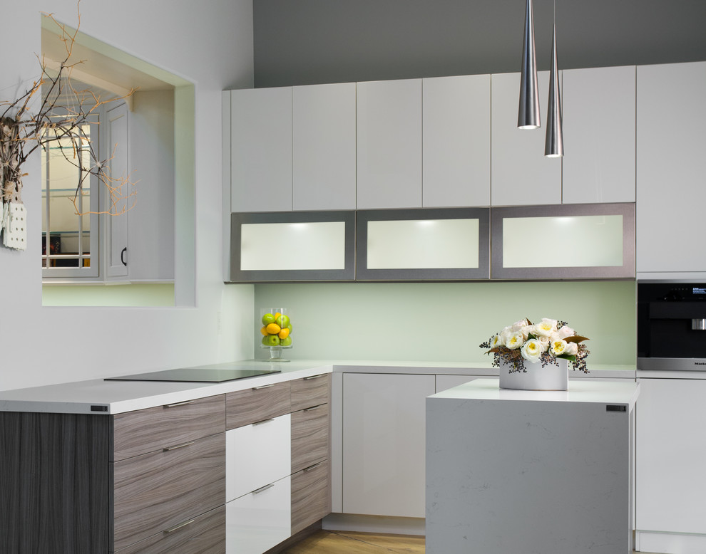 This is an example of a small modern l-shaped kitchen/diner in San Francisco with beaded cabinets, white cabinets, quartz worktops, white splashback, stainless steel appliances, light hardwood flooring, an island and beige floors.