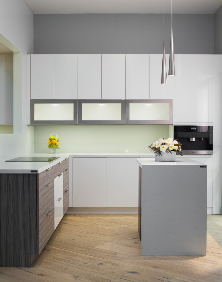 Inspiration for a small modern l-shaped kitchen/diner in San Francisco with beaded cabinets, white cabinets, quartz worktops, white splashback, stainless steel appliances, light hardwood flooring, an island and beige floors.