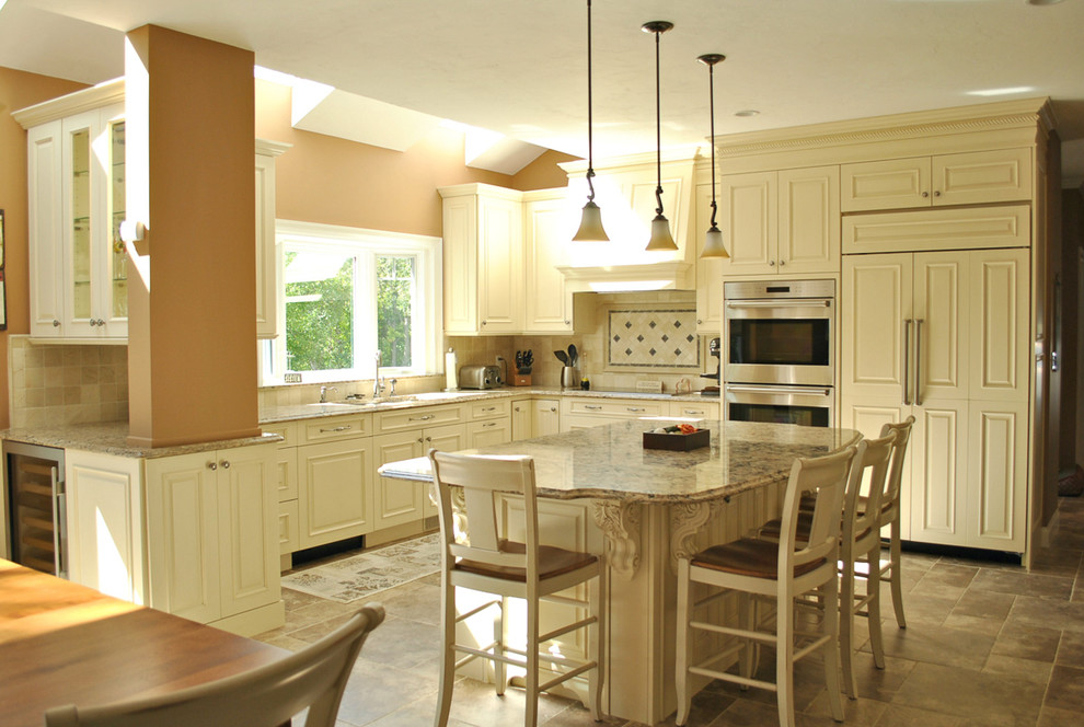 Klassisk inredning av ett kök, med en undermonterad diskho, luckor med upphöjd panel, vita skåp, bänkskiva i kvarts, beige stänkskydd, stänkskydd i keramik, rostfria vitvaror, klinkergolv i keramik och en köksö