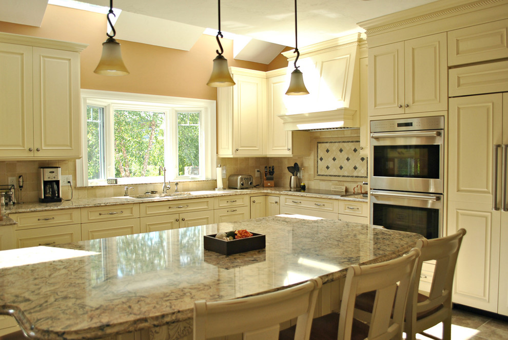 Eat-in kitchen - traditional l-shaped ceramic tile eat-in kitchen idea in Boston with an undermount sink, raised-panel cabinets, white cabinets, quartz countertops, beige backsplash, ceramic backsplash, stainless steel appliances and an island