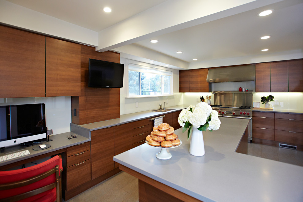 Foto på ett kök, med en undermonterad diskho, släta luckor, bänkskiva i kvarts, vitt stänkskydd, glaspanel som stänkskydd, rostfria vitvaror, korkgolv och en köksö