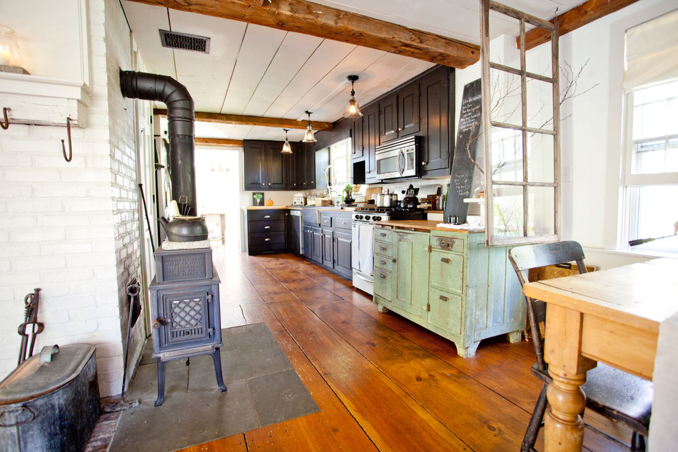 This is an example of a country kitchen in Boston with black cabinets.