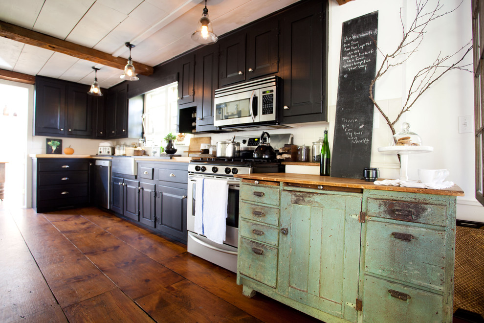 Idéer för ett lantligt kök, med en rustik diskho, luckor med upphöjd panel, svarta skåp och rostfria vitvaror