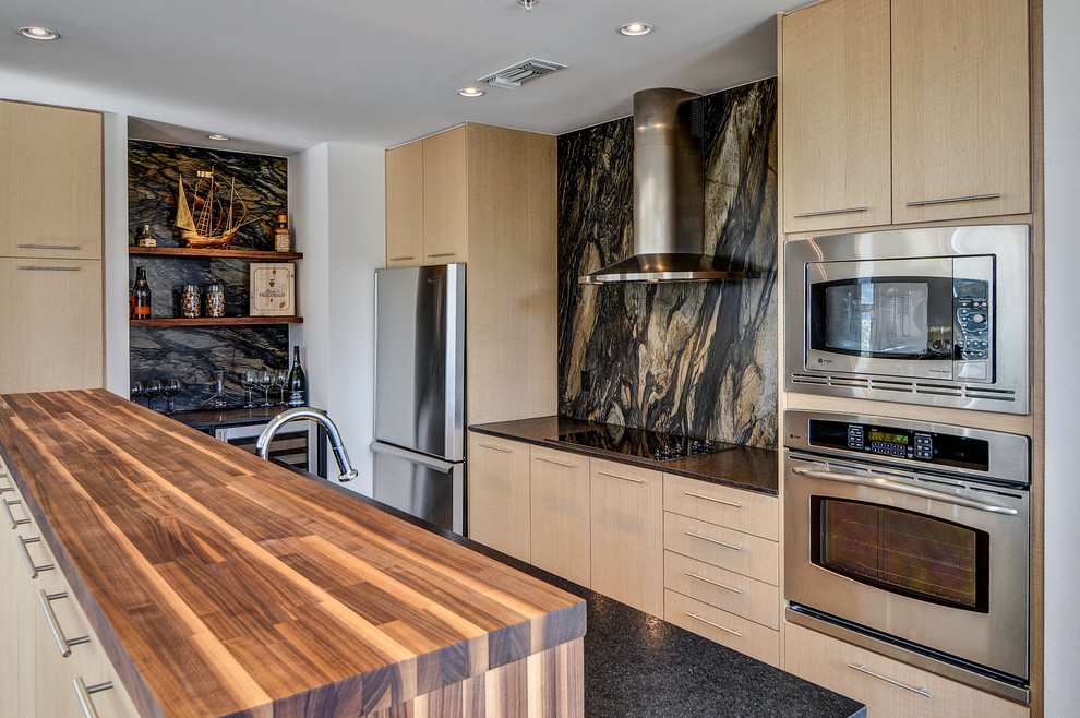 Mittelgroße Moderne Küche in U-Form mit flächenbündigen Schrankfronten, hellen Holzschränken, bunter Rückwand und Küchengeräten aus Edelstahl in Dallas