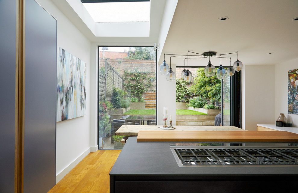 Exempel på ett stort modernt kök, med en integrerad diskho, släta luckor, lila skåp, bänkskiva i koppar, vitt stänkskydd, stänkskydd i sten, rostfria vitvaror, mellanmörkt trägolv, en köksö och brunt golv