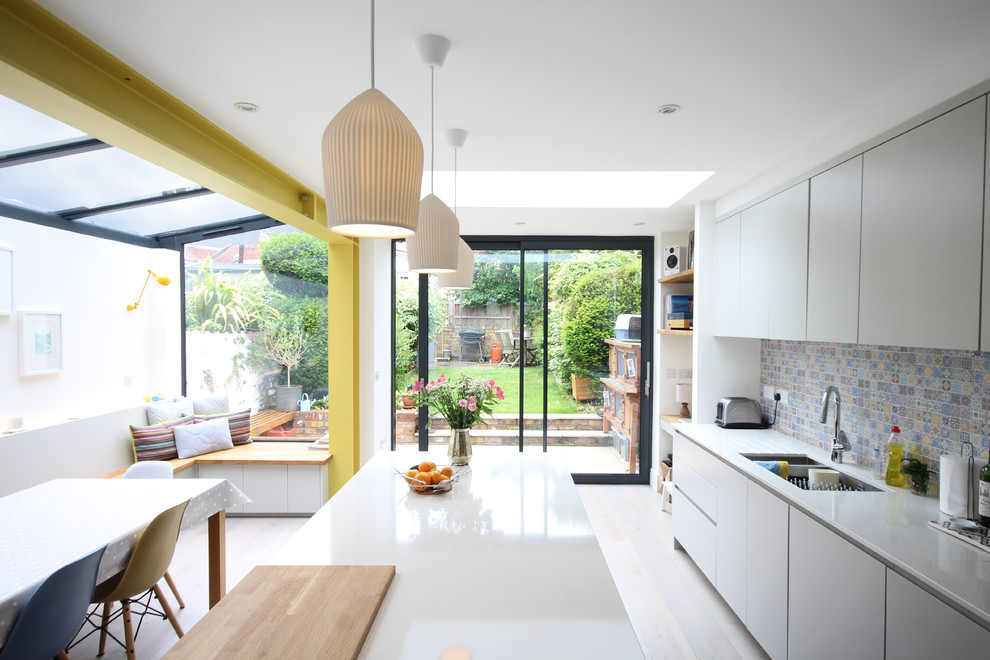 Inspiration for a medium sized contemporary galley open plan kitchen in Other with flat-panel cabinets, grey cabinets, quartz worktops, multi-coloured splashback, ceramic splashback, an island, white floors and white worktops.