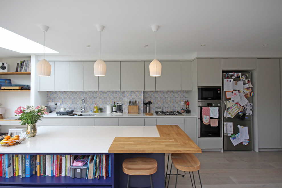 Immagine di una cucina design di medie dimensioni con ante lisce, ante grigie, top in quarzite, paraspruzzi multicolore, paraspruzzi con piastrelle in ceramica, parquet chiaro e top beige