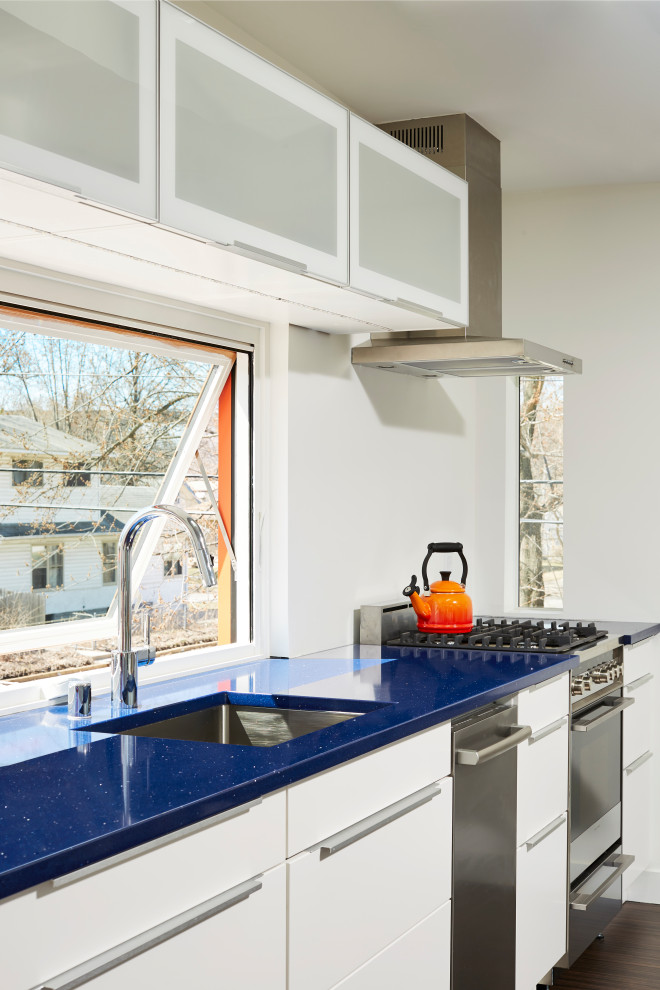 Idéer för att renovera ett litet 50 tals blå linjärt blått kök, med en undermonterad diskho, släta luckor, vita skåp, fönster som stänkskydd och rostfria vitvaror
