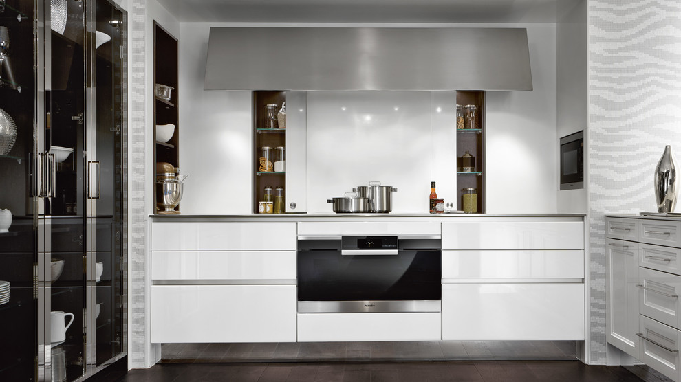 Inspiration för ett mellanstort funkis kök, med en integrerad diskho, vita skåp, bänkskiva i rostfritt stål, vitt stänkskydd, stänkskydd i sten, rostfria vitvaror, mörkt trägolv och brunt golv