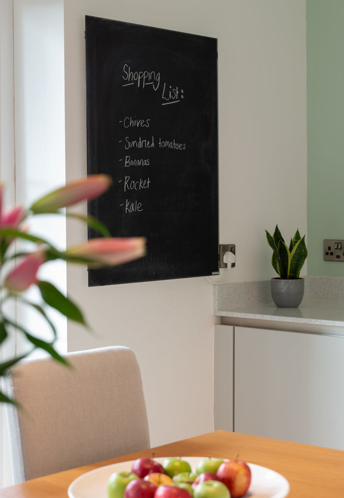 Immagine di una piccola cucina abitabile moderna con ante lisce, ante grigie e top in quarzo composito