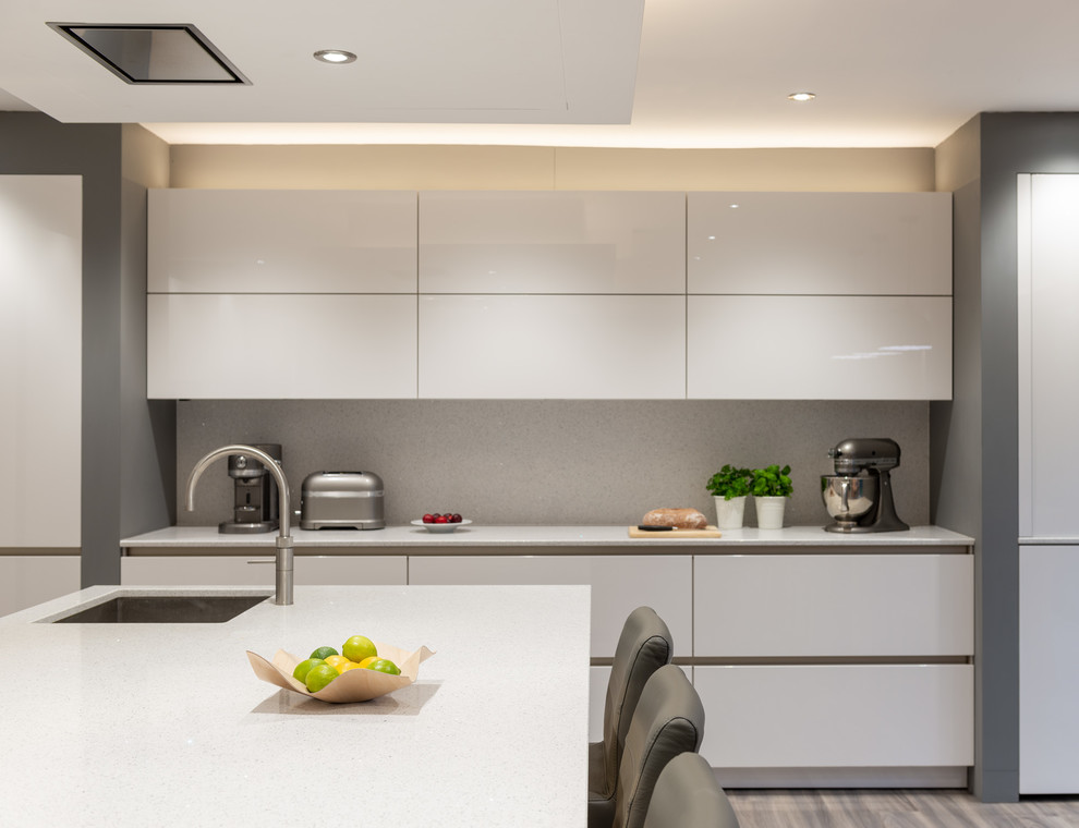 Immagine di una cucina moderna di medie dimensioni con ante bianche, top in quarzo composito, elettrodomestici neri, pavimento grigio e top bianco
