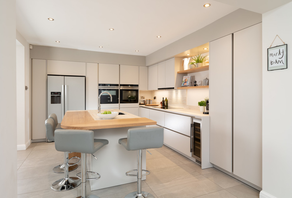 Photo of a medium sized contemporary l-shaped kitchen/diner in Other with flat-panel cabinets, grey cabinets, engineered stone countertops, porcelain flooring, grey floors, a submerged sink, stainless steel appliances, an island and white worktops.