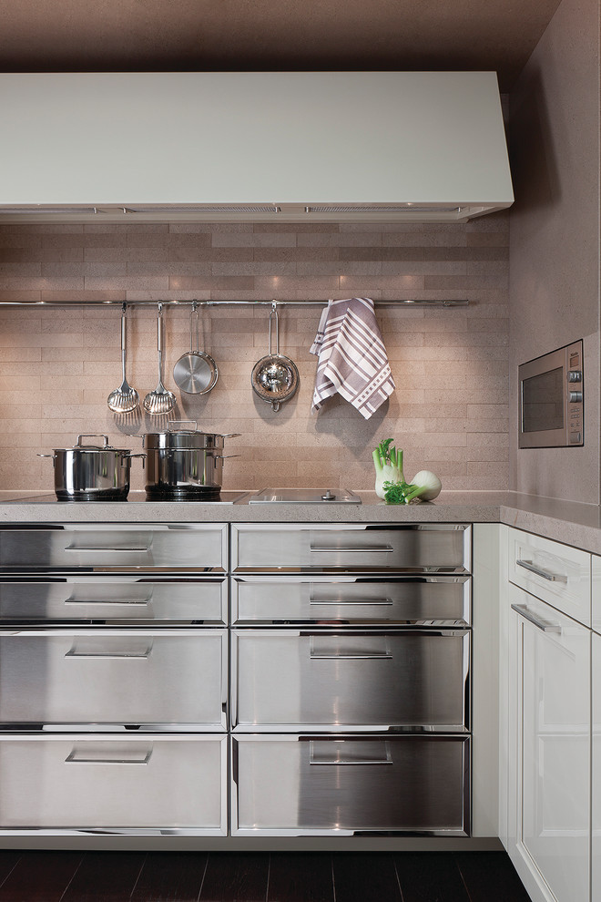 Modern inredning av ett kök och matrum, med luckor med infälld panel, skåp i rostfritt stål, bänkskiva i kalksten, beige stänkskydd och stänkskydd i stenkakel