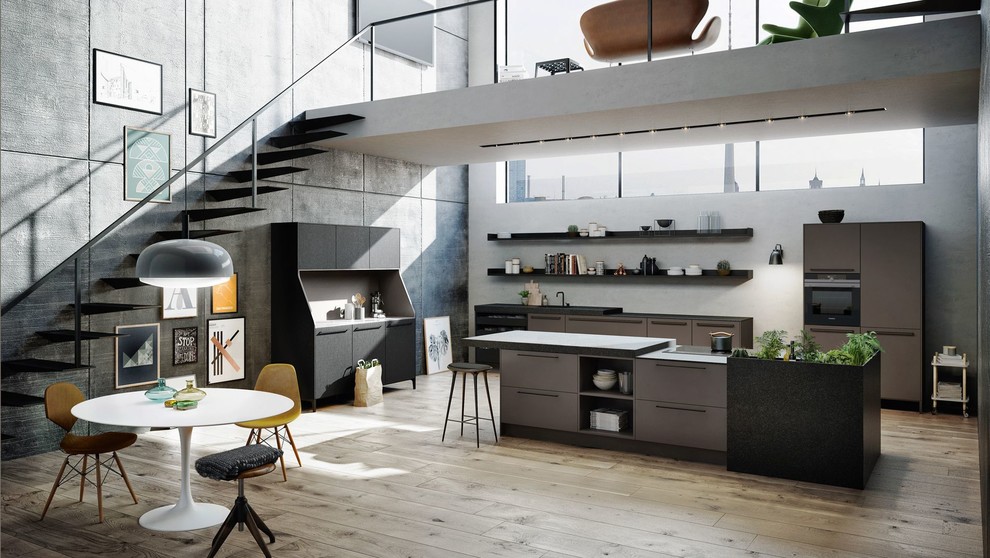 Ejemplo de cocinas en L moderna grande abierta con electrodomésticos negros, suelo de madera clara, península y suelo marrón