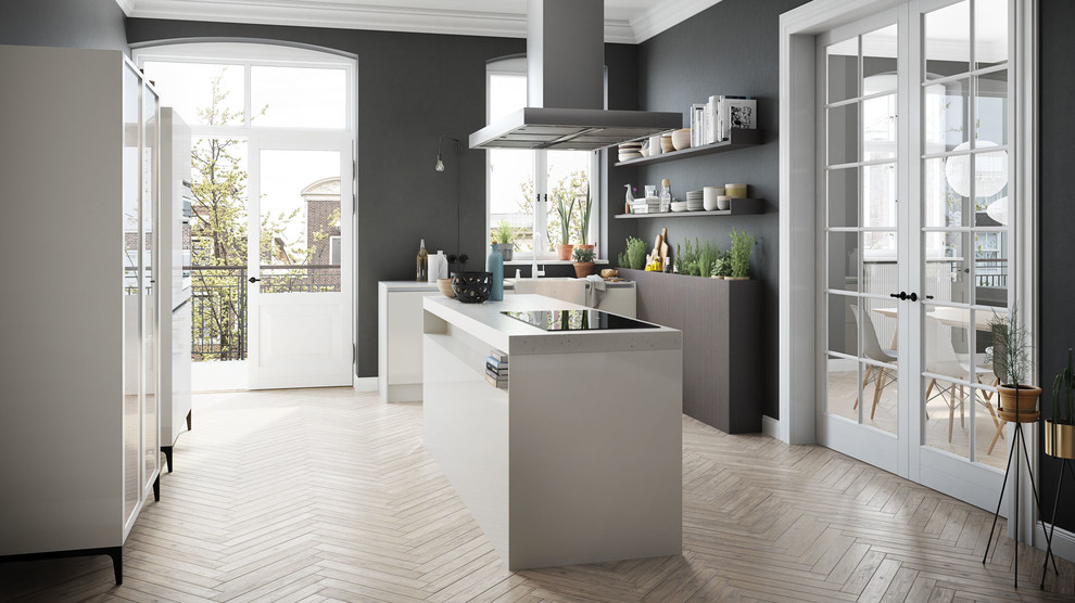 Diseño de cocina comedor lineal moderna de tamaño medio con puertas de armario blancas, una isla, fregadero de un seno, suelo de madera clara y suelo marrón
