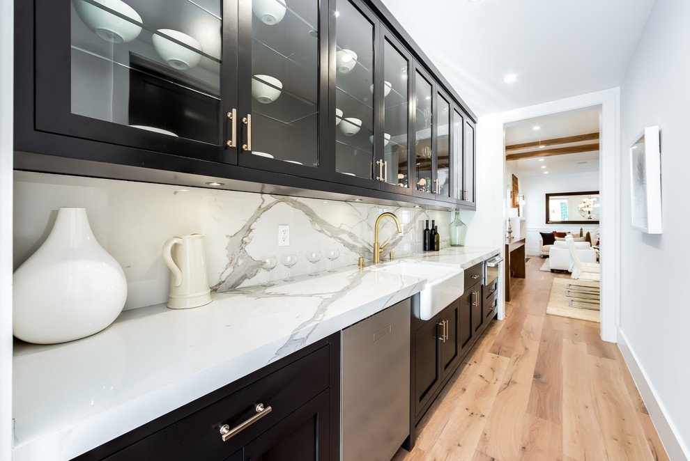 Klassisk inredning av ett vit linjärt vitt kök, med en rustik diskho, skåp i shakerstil, svarta skåp, vitt stänkskydd, rostfria vitvaror, ljust trägolv och beiget golv