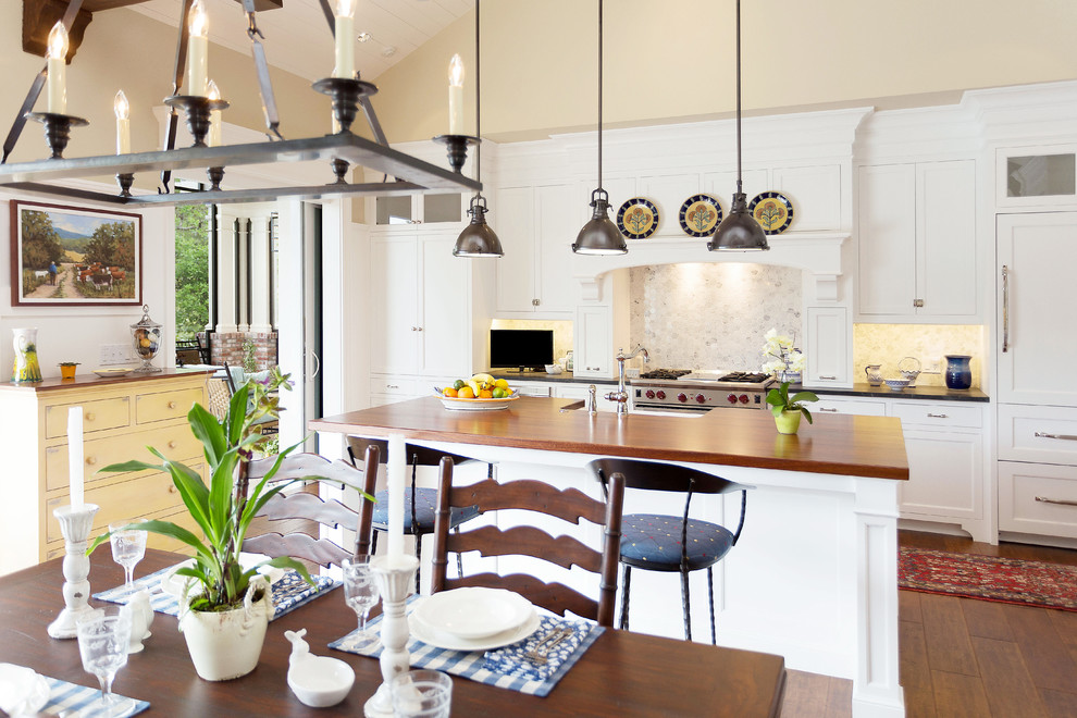 На фото: п-образная кухня-гостиная среднего размера в классическом стиле с белыми фасадами и островом