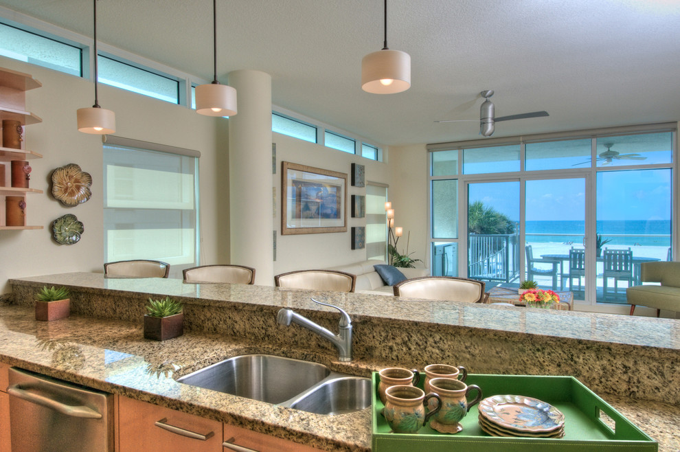Mid-sized island style galley eat-in kitchen photo in Tampa with an undermount sink, granite countertops, multicolored backsplash, stone tile backsplash, stainless steel appliances and an island