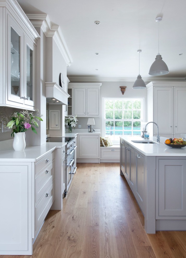 Landhaus Küche mit Schrankfronten im Shaker-Stil, grauen Schränken und hellem Holzboden in Sonstige