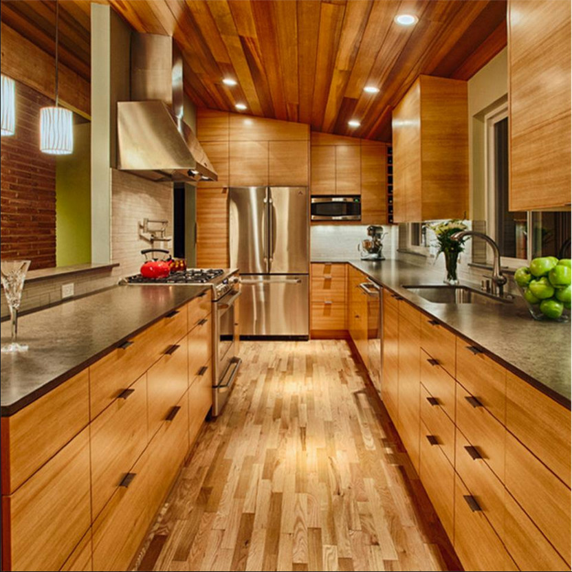 Example of a mid-sized trendy galley light wood floor enclosed kitchen design in Houston with a drop-in sink, flat-panel cabinets, light wood cabinets, stainless steel appliances, no island and beige backsplash