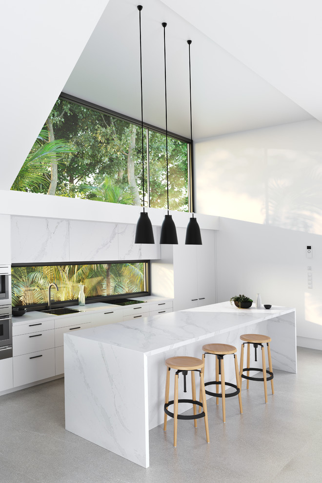 На фото: параллельная кухня-гостиная у окна в стиле модернизм с плоскими фасадами, белыми фасадами, мраморной столешницей, техникой из нержавеющей стали, бетонным полом, островом и серым полом с