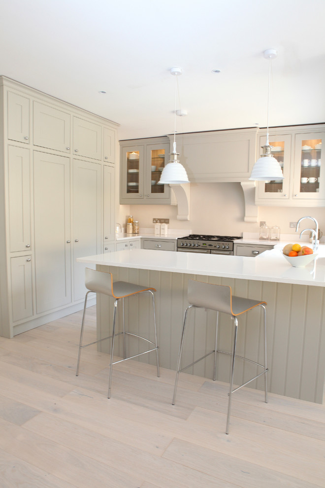 Example of a mid-sized farmhouse light wood floor kitchen design in Wiltshire with gray cabinets, stainless steel appliances, beige backsplash and beaded inset cabinets