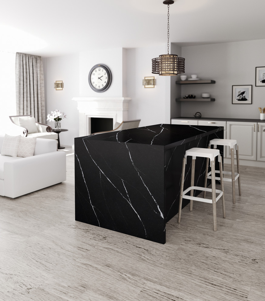 Example of a trendy kitchen design in Hampshire with quartzite countertops, black appliances and an island