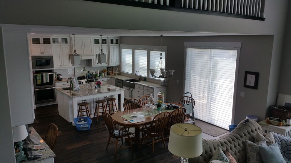 Foto på ett stort maritimt kök och matrum, med en enkel diskho, skåp i ljust trä, granitbänkskiva, rostfria vitvaror, mellanmörkt trägolv och en köksö