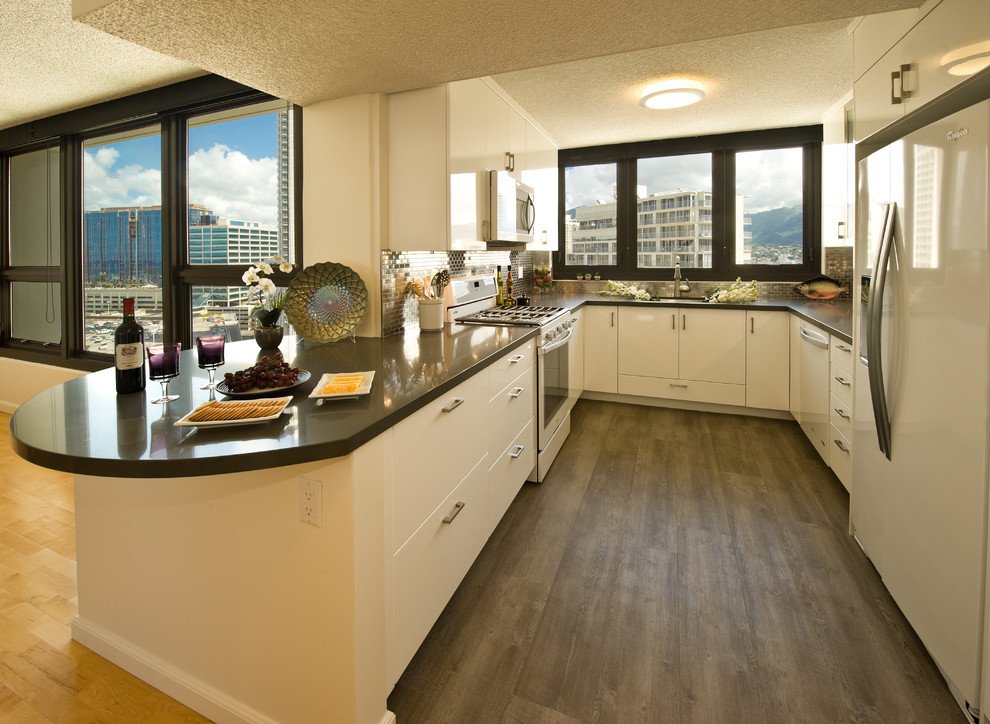 Example of a small trendy u-shaped kitchen design in Hawaii with an undermount sink, flat-panel cabinets, white cabinets, metallic backsplash, white appliances and an island