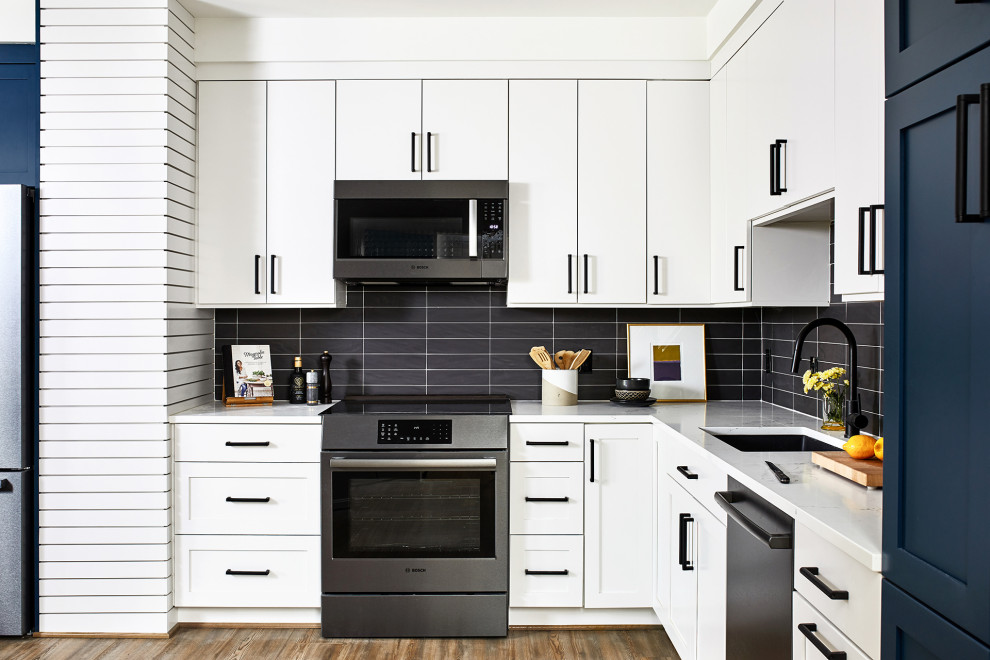 Esempio di una cucina abitabile classica di medie dimensioni con ante bianche, paraspruzzi nero, paraspruzzi con piastrelle diamantate, elettrodomestici neri, pavimento in legno massello medio e top bianco
