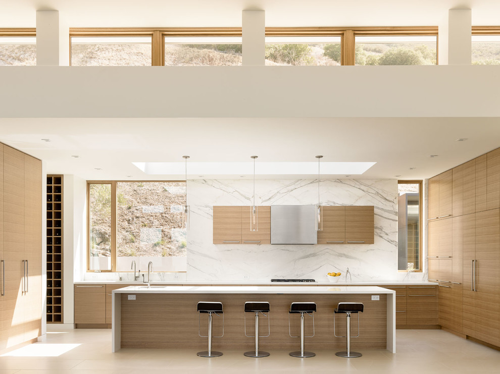 Moderne Küche mit flächenbündigen Schrankfronten, hellen Holzschränken, Küchenrückwand in Weiß, Elektrogeräten mit Frontblende und Kücheninsel in San Francisco
