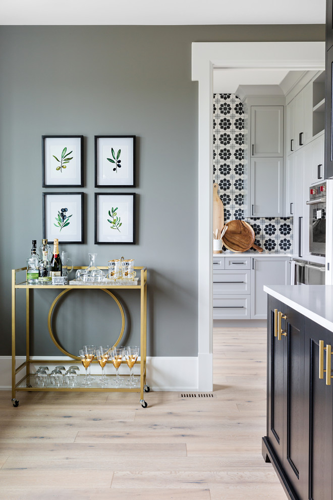 Design ideas for an expansive traditional galley kitchen pantry in Calgary with black cabinets, integrated appliances, light hardwood flooring and shaker cabinets.