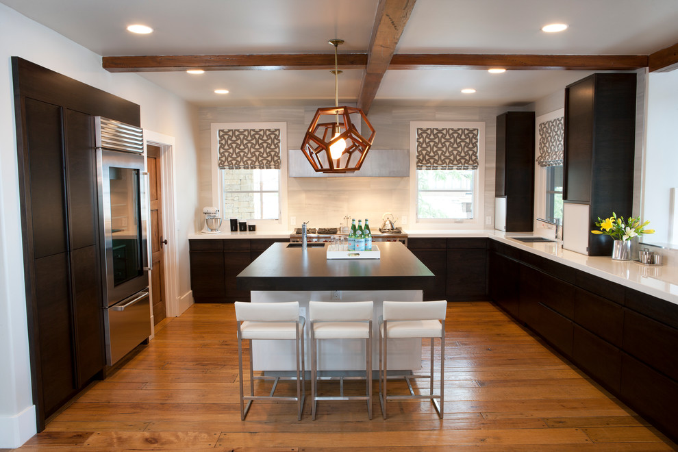 Transitional u-shaped eat-in kitchen photo in Salt Lake City with an undermount sink, flat-panel cabinets, black cabinets, glass countertops, white backsplash, stone tile backsplash and stainless steel appliances