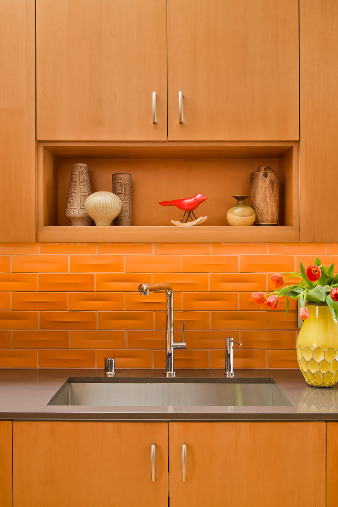 Medium sized retro l-shaped open plan kitchen in Los Angeles with a built-in sink, flat-panel cabinets, light wood cabinets, orange splashback, stainless steel appliances, light hardwood flooring and no island.