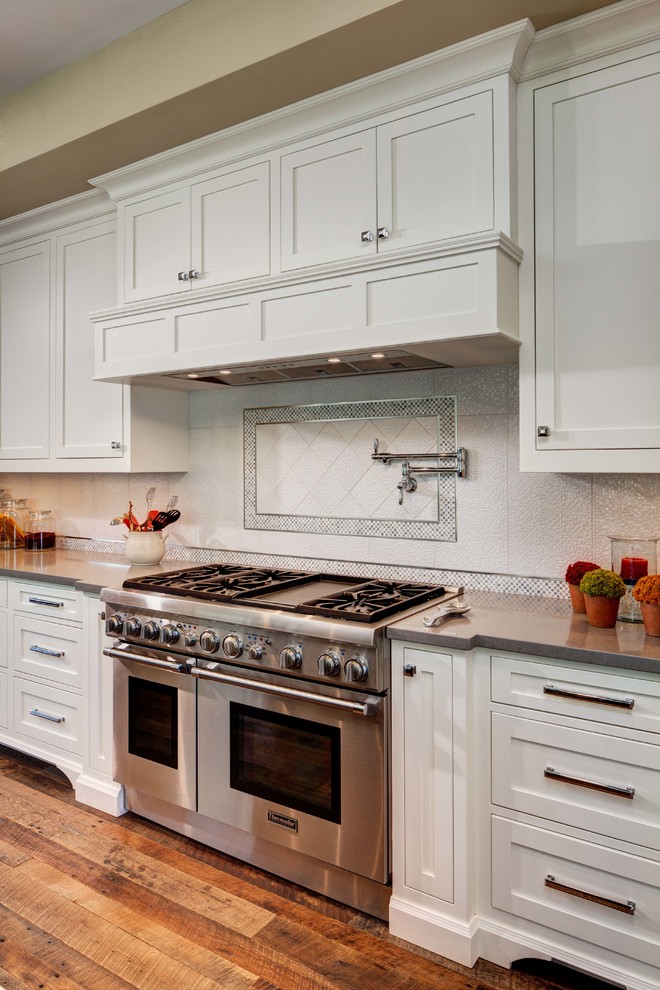 Tuscan u-shaped eat-in kitchen photo in Phoenix with a double-bowl sink, recessed-panel cabinets, white cabinets, limestone countertops, white backsplash and stainless steel appliances