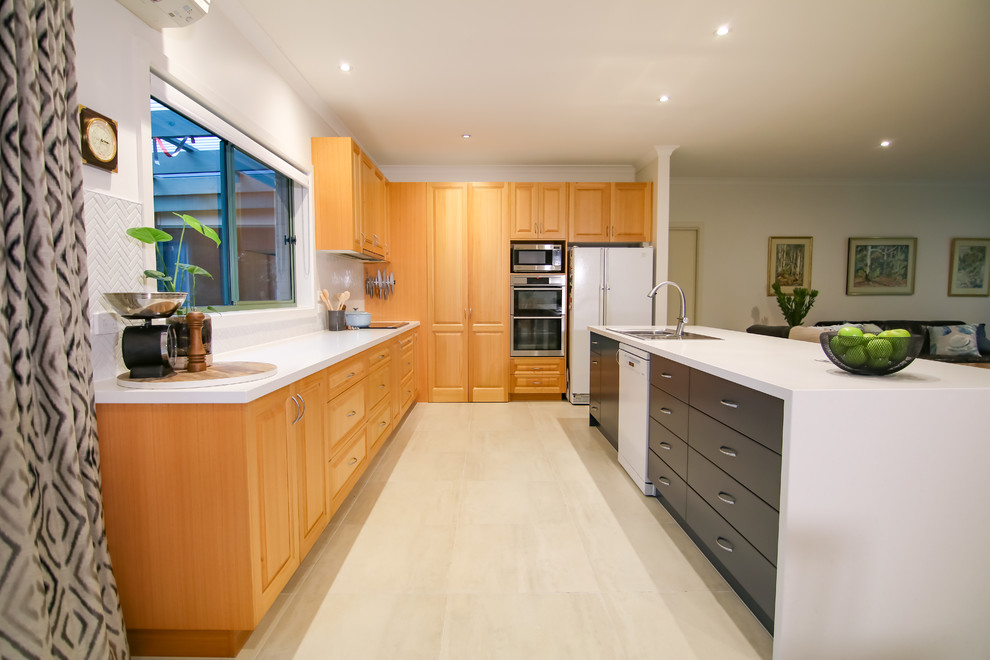 Foto på ett stort funkis kök med öppen planlösning, med en dubbel diskho, vitt stänkskydd, stänkskydd i keramik, vita vitvaror, klinkergolv i keramik och en köksö
