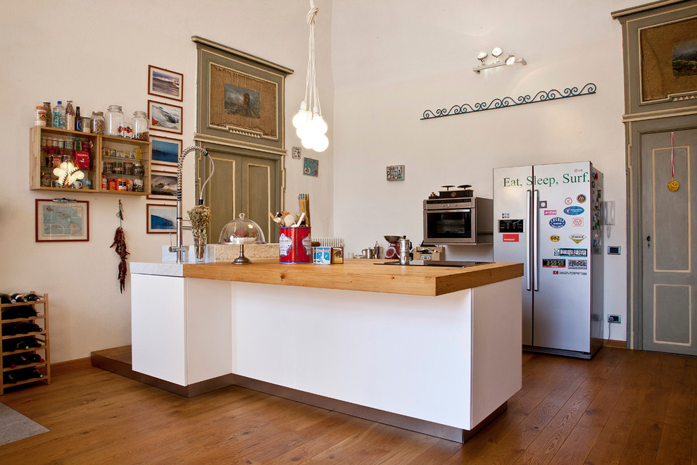 Stilmix Küche mit Arbeitsplatte aus Holz, Küchengeräten aus Edelstahl, braunem Holzboden und Kücheninsel in Turin