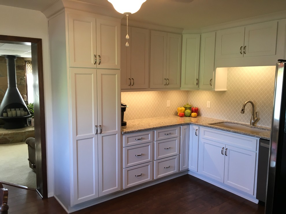 Mittelgroße Moderne Küche in U-Form mit Küchenrückwand in Weiß, Rückwand aus Keramikfliesen, Küchengeräten aus Edelstahl, dunklem Holzboden, Kücheninsel und braunem Boden in Indianapolis