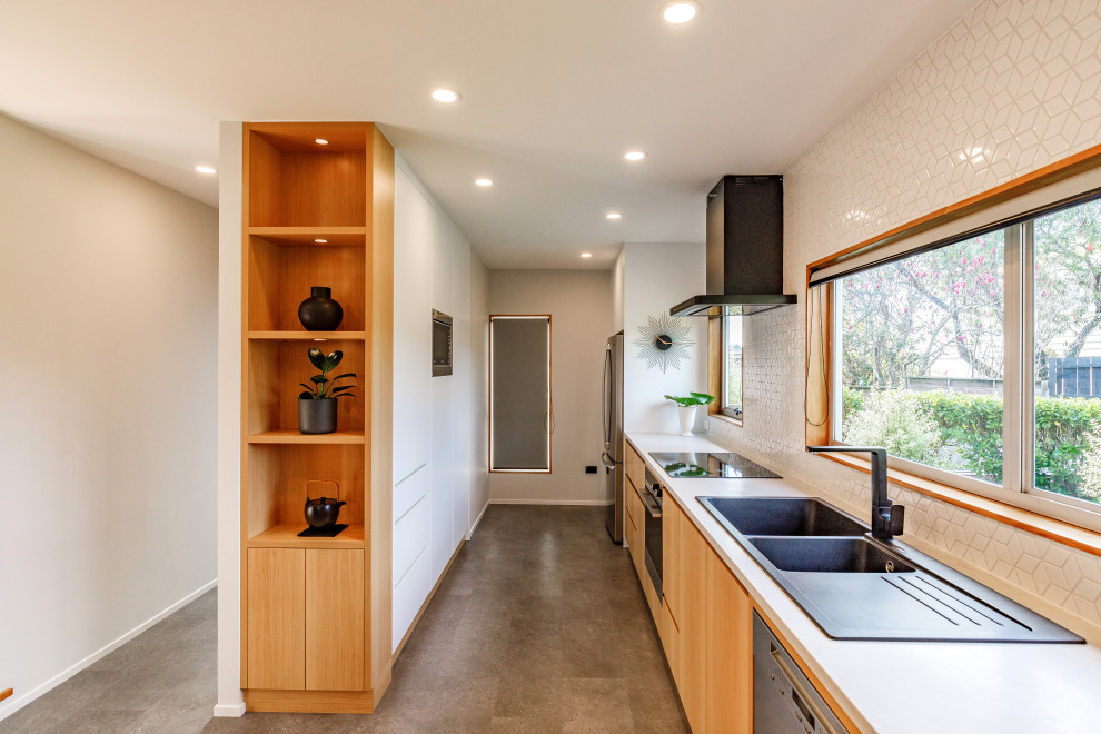 Inspiration for a medium sized contemporary galley kitchen/diner in Auckland with a double-bowl sink, engineered stone countertops, white splashback, mosaic tiled splashback, stainless steel appliances, lino flooring, a breakfast bar, grey floors and white worktops.