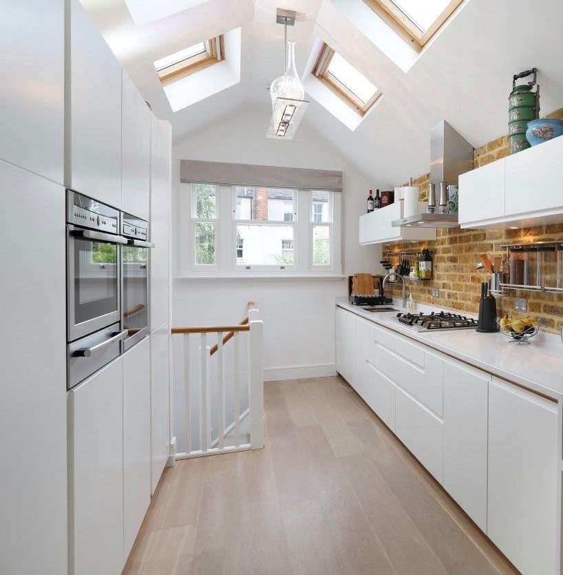 Foto di una cucina scandinava di medie dimensioni con ante lisce, ante bianche, top in quarzite, paraspruzzi in mattoni, elettrodomestici in acciaio inossidabile, parquet chiaro e top bianco