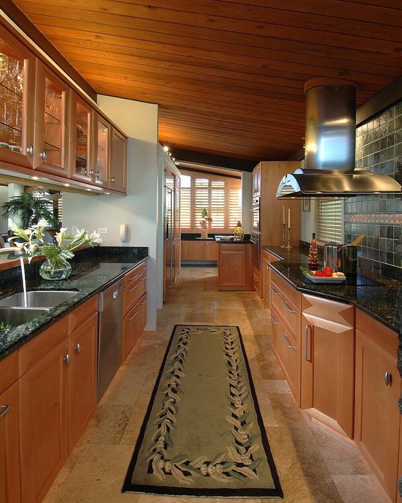 ハワイにあるコンテンポラリースタイルのおしゃれなII型キッチン (ガラス扉のキャビネット、シルバーの調理設備、アンダーカウンターシンク、中間色木目調キャビネット、緑のキッチンカウンター) の写真