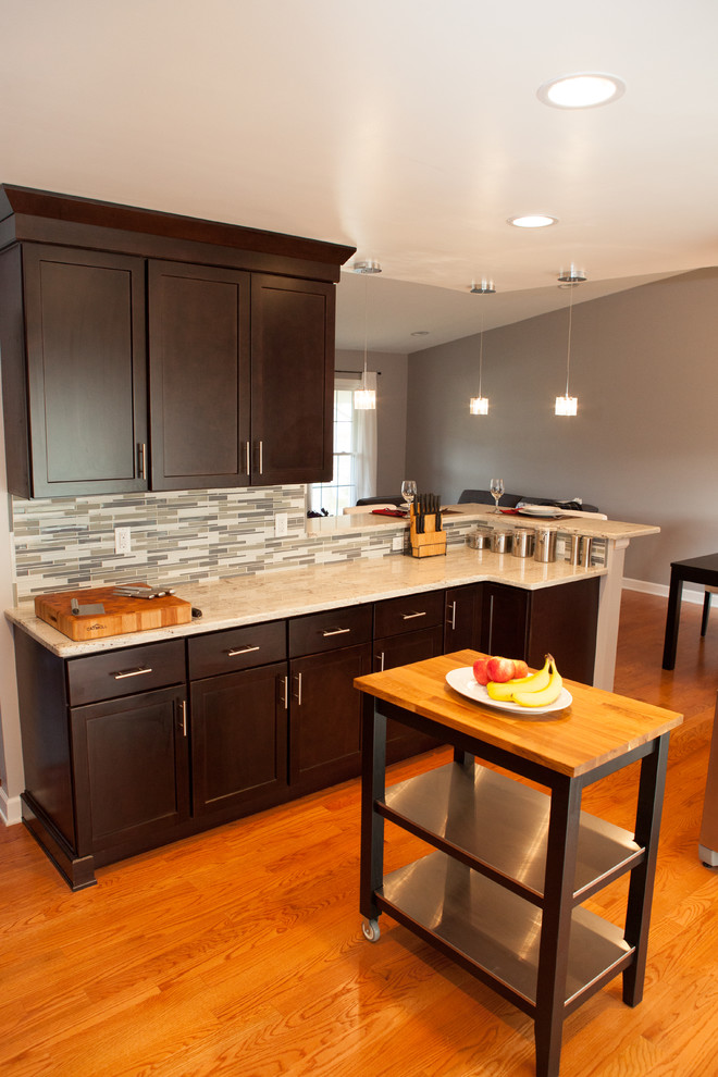 Exempel på ett litet modernt kök, med skåp i shakerstil, granitbänkskiva, stänkskydd i glaskakel, rostfria vitvaror, en undermonterad diskho, skåp i mörkt trä, grått stänkskydd och ljust trägolv