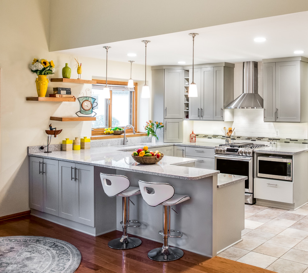 Esempio di una cucina ad U classica di medie dimensioni con ante in stile shaker, ante grigie, paraspruzzi bianco, pavimento beige e parquet e piastrelle