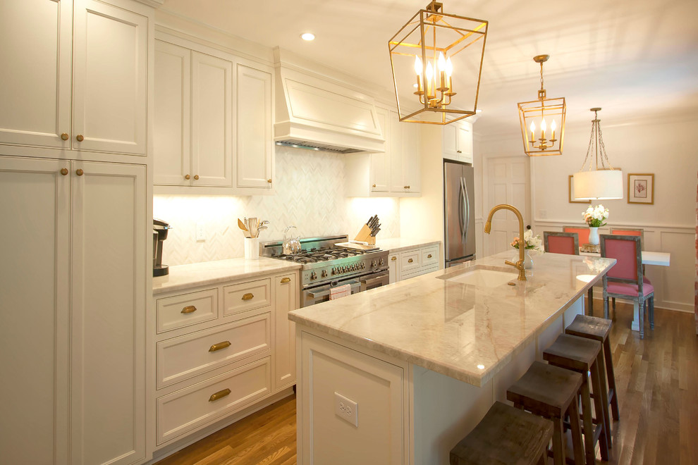 Inspiration for a mid-sized transitional galley light wood floor eat-in kitchen remodel in Charlotte with a single-bowl sink, beaded inset cabinets, white cabinets, granite countertops, white backsplash, stainless steel appliances and an island