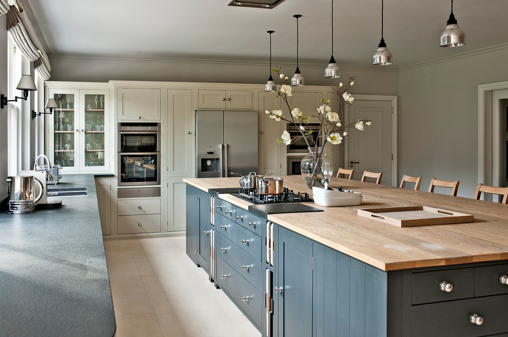 Large trendy enclosed kitchen photo in Gloucestershire with shaker cabinets, gray cabinets, wood countertops, stainless steel appliances and an island